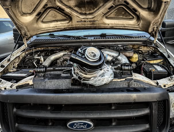 Ford Diesel truck engine with open hood showing engine components and a diesel turbo charger.
